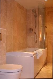 斯特灵Kingsview Apartment的带浴缸、卫生间和淋浴的浴室。