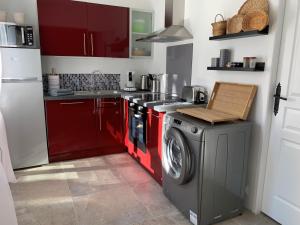 圣吉尔Solimany的一间带红色橱柜和洗衣机的厨房