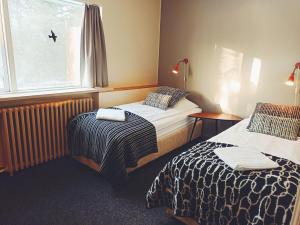 塞尔福斯Hotel Hjardarbol的酒店客房设有两张床和窗户。