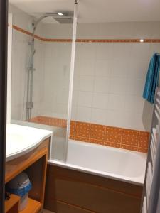 贝诺代Corniche de la Plage classé 3 étoiles的带淋浴和白色浴缸的浴室