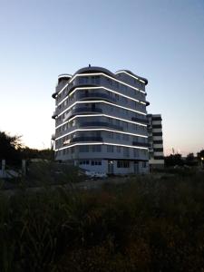 北马马亚-讷沃达里Apartament Somnila, Mamaia Nord的一座高大的白色建筑,有很多窗户