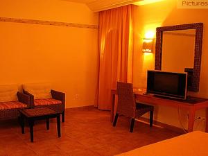 杜兹撒哈拉杜兹酒店的酒店客房配有电视、书桌和椅子