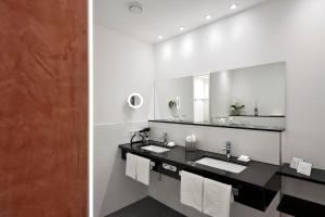 汉诺威路易森霍夫卡斯腾酒店的一间带两个盥洗盆和大镜子的浴室