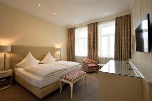 汉诺威路易森霍夫卡斯腾酒店的配有一张床和一张书桌的酒店客房