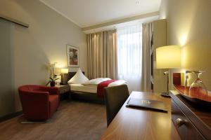 汉诺威路易森霍夫卡斯腾酒店的配有一张床、一张桌子和一张桌子的酒店客房