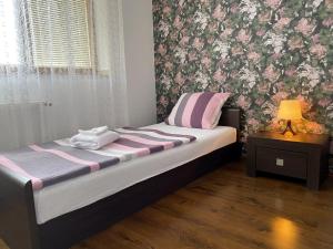 奥洛穆茨格洛丽亚宾馆的一间卧室配有一张粉红色和紫色壁纸的床