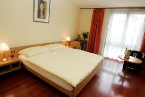 德莱蒙勒纳申尔酒店的一间卧室设有一张大床和一个窗户。