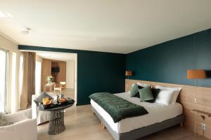 拉格朗德默特Hôtel Les Corallines – Thalasso & Spa的一间卧室设有一张床和蓝色的墙壁