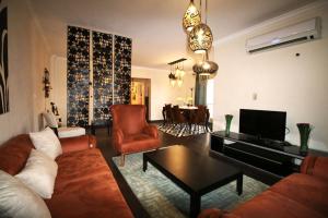 开罗Elegant home in Madinaty compound的客厅配有沙发、椅子和电视