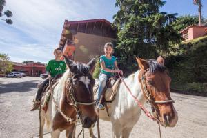 坎波斯杜若尔当Hotel Recanto São Cristóvão - Próximo ao Parque Tarundu的骑着马的男孩和女孩