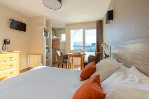 隆勒索涅温泉浴场公寓酒店的一间卧室配有一张床、一张桌子和一个窗户。