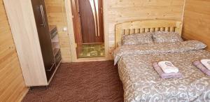 亚布卢尼齐亚Marichka的木制客房内的一间卧室,配有一张床