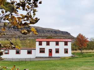 都皮沃古尔Fossardalur Guesthouse的山前有红门的白色房子