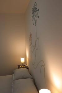滨海波利尼亚诺乌恩索格诺科西公寓的卧室配有一张挂着花壁画的床。
