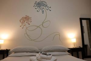 滨海波利尼亚诺乌恩索格诺科西公寓的卧室配有一张墙上鲜花的床
