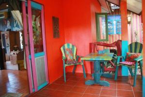 拉迈Varinda Resort的红色墙壁的房间里一张桌子和椅子