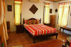 拉迈Varinda Resort的一间卧室配有一张带彩色条纹毯子的床