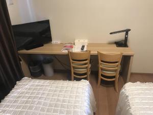 宜野湾市Weekly Harbourview Mansion Ginowan / Vacation STAY 74625的一张桌子,两张椅子和一张位于房间里的床