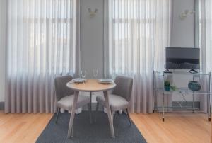 波尔图卡里祖城市休闲公寓的一间带桌椅和电视的用餐室
