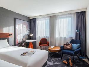 阿姆斯特丹Mercure Amsterdam City Hotel的酒店客房,配有一张床、一张桌子和椅子