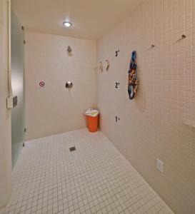 星期五港埃兰迪因123韦斯特酒店的浴室设有瓷砖淋浴和橙色垃圾桶