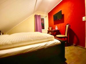 巴特布拉姆施泰特Der Gutschmecker Bad Bramstedt的一间卧室配有一张红色墙壁的床