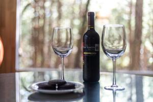 马萨米特拉Rincon de Maria Mazamitla的桌子上放有一瓶葡萄酒和两杯酒