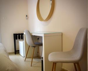 耶路撒冷B12 Inn的一间卧室配有书桌、两把椅子和镜子