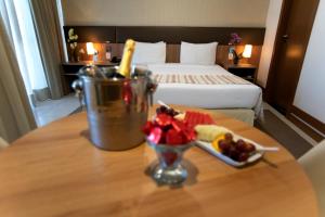 巴西利亚阿托斯布尔考普拉斯行政酒店的一张桌子,上面放着一碗水果放在酒店房间的桌子上