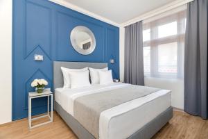 布拉格Eight Secrets Boutique Residence的一间蓝色的卧室,配有一张大床和镜子