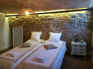 La PeraCan Puig de la Pera的石墙客房的两张床