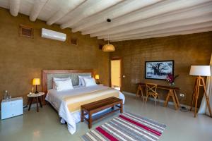 曼克拉Adobe Villas的一间卧室配有一张床、一张桌子和一张地毯。