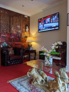 布莱克浦新吉尔德罗伊酒店的客厅的墙上配有电视