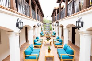 圣巴巴拉La Playa Inn Santa Barbara的建筑庭院里一排蓝色的椅子