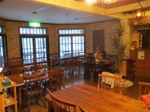白马村马利翁奈特旅馆的餐厅设有木桌、椅子和窗户。