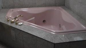 奥克兰Laurel Inn的浴室内设有带水龙头的粉红色浴缸