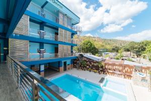 奥隆阿波RedDoorz Premium @ Casa Ghilda Resort Olongapo City的一个带游泳池和大楼的阳台