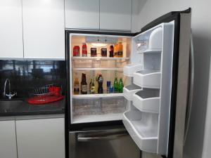 墨西哥城阿尔莫尼套房酒店的厨房里设有冰箱,门开