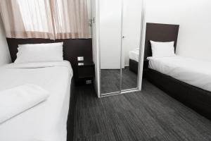 霍巴特St Ives Apartments的酒店客房,设有两张床和镜子