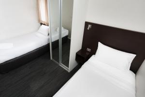 霍巴特St Ives Apartments的酒店客房,设有两张床和镜子
