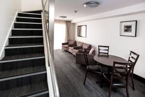 霍巴特St Ives Apartments的客房设有楼梯和桌椅