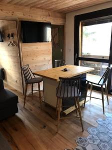 拉萨尔莱阿尔佩Ambiance petit chalet的客房设有木桌、椅子和电视。