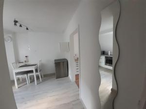 LederbergHeumaden hell und gemütlich eingerichtete 1-Zimmer Wohnung的白色的客房设有桌子和厨房