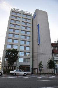 松山Smile Hotel Matsuyama的停在大楼前的白色汽车