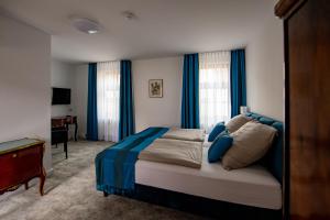 爱尔福特Haus Maximilian的一间卧室配有一张带蓝色窗帘的大床