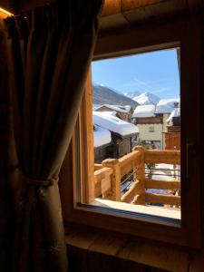 利维尼奥Le Chalet Luxury Apartment的享有白雪 ⁇ 山景的窗户