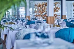 马略卡岛帕尔马Calanova Sports Residence的用餐室配有白色的桌子和蓝色的椅子