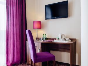 卢布涅维采沃茵斯基Spa酒店的酒店客房配有一张带紫色椅子的书桌