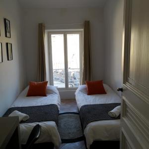 卡斯泰尔诺达里Suite Familiale Saint-Exupéry-Spacieux-Hypercentre-wifi-vélo的带窗户的客房内的两张床