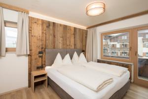 阿尔普巴赫谷地赖特Angerer Alpine Suiten und Familienappartements Tirol的卧室设有一张白色大床和一扇窗户。